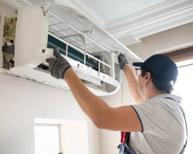 Technician opening an indoor ductless HVAC unit for detailed service