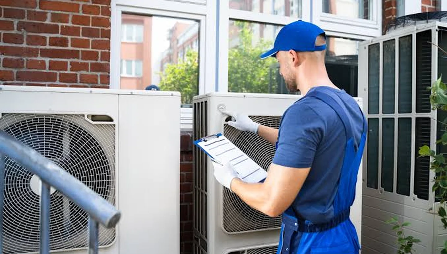 HVAC technician inspecting residential outdoor cooling equipment for Bellcrest HVAC Services