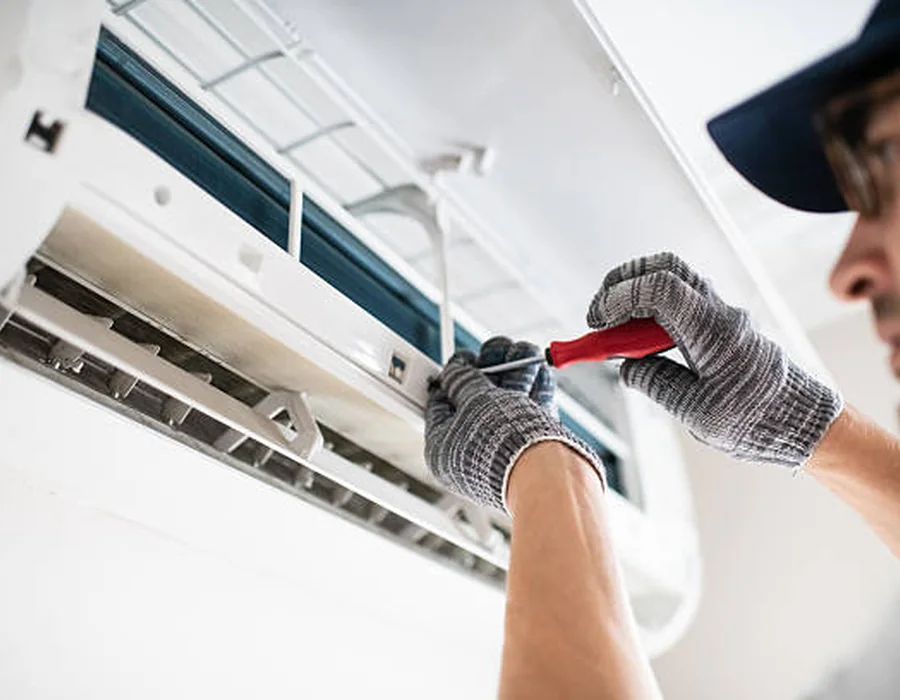 Close-up HVAC technician servicing an indoor wall-mounted system